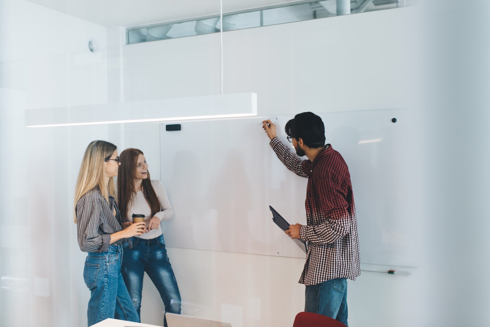 Colleagues discussing ideas at a whiteboard; illustrative photography