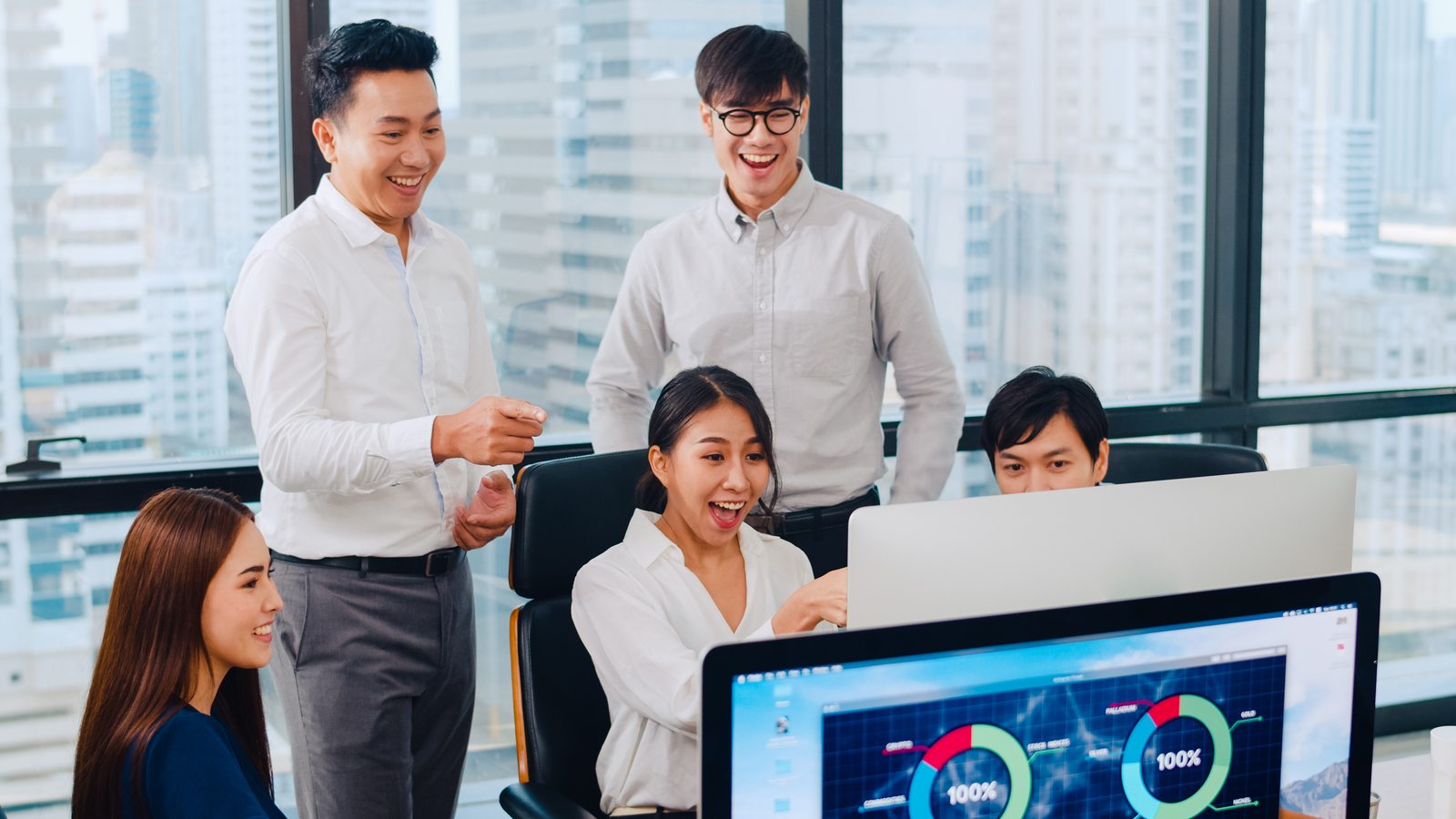 Colleagues reviewing work together around a computer; illustrative photography