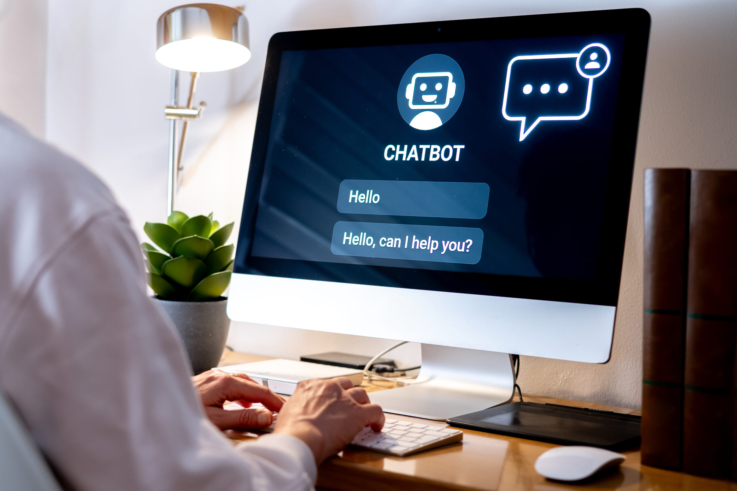 Person using a computer with a chatbot on screen; illustrative stock photograph