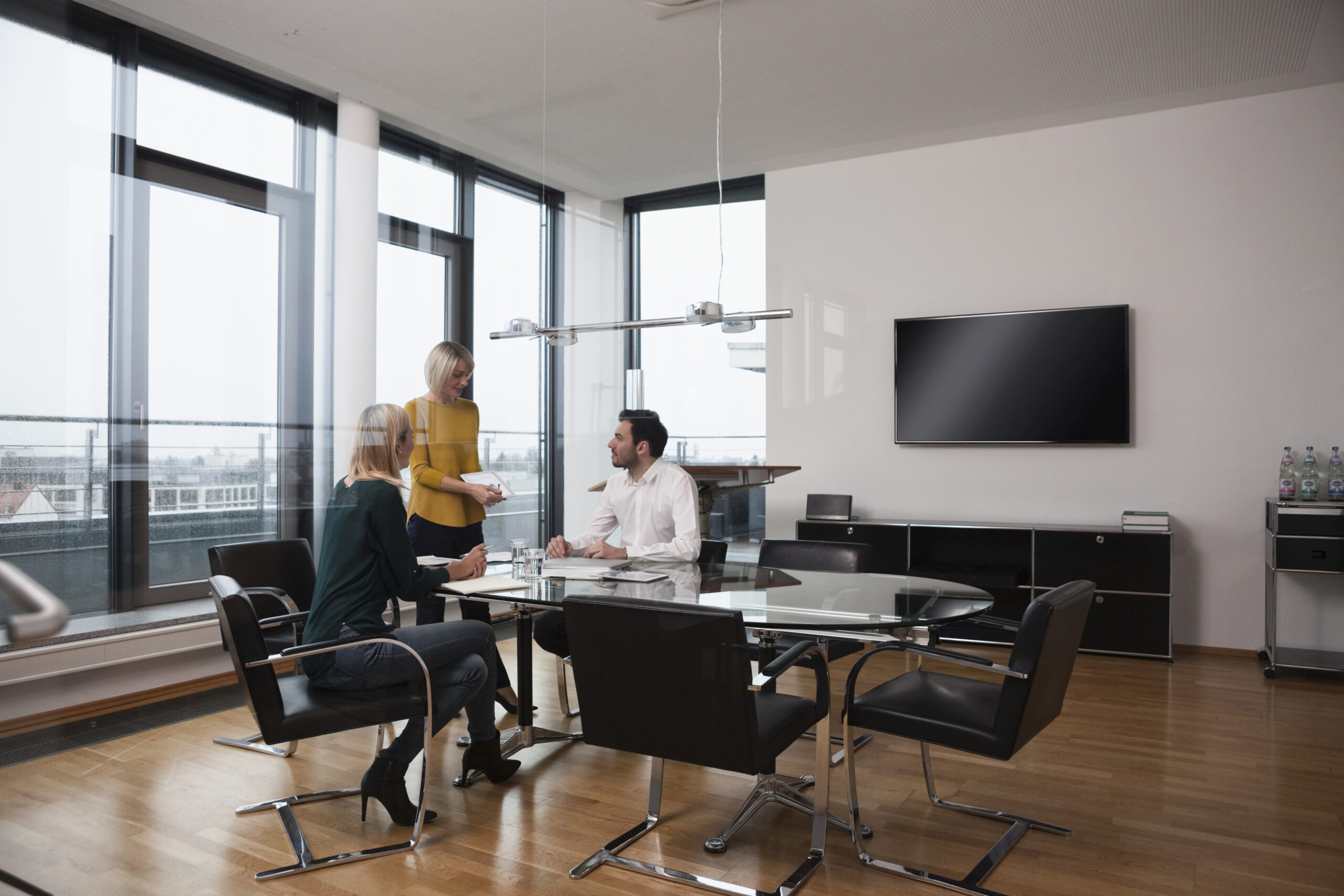 Colleagues reviewing documents in a contemporary boardroom; illustrative stock photograph